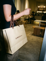 Sacs shopping en papier de luxe personnalisés avec impression couleur, logo en feuille d'or noir, lignes en relief et poignées en corde marron
