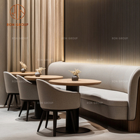 Ensemble de mobilier de café-restaurant : canapé banquette incurvé en velours beige, tables rondes en bois et chaises à assise en tissu pour café