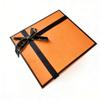 Boîte cadeau en carton magnétique orange avec logo personnalisé, ruban et fleurs, caractéristique aseptique pour offrir des bougies