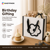 Sac en papier blanc personnalisé avec poignée en ruban noir, pelliculage mat, motif floral imprimé pour les boutiques de cadeaux et les magasins de détail