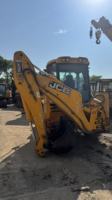 Chargeuse-pelleteuse JCB 4CX/3CX d'occasion jaune, équipement de construction avec godet et bras d'excavation, bon état, moteur pour usage intensif