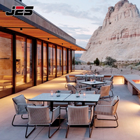 Ensemble de mobilier de patio J2S en métal et bois avec coussin et table, idéal pour les restaurants commerciaux modernes en extérieur et les stations balnéaires.