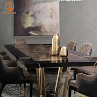 Table à manger moderne de luxe en marbre foncé avec pieds géométriques en métal doré, cadre noir, mobilier haut de gamme pour la décoration de salle à manger de villa