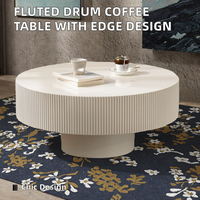 Table basse de style européen moderne, design tambour cannelé, plateau en pierre à bords embossés, structure en bois, piétement durable, table centrale blanche