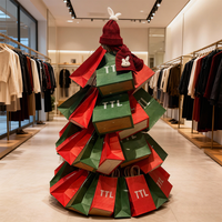 Sacs en papier kraft empilés de manière créative en forme de sapin de Noël, ajoutant une touche festive à l'affichage des magasins de vêtements