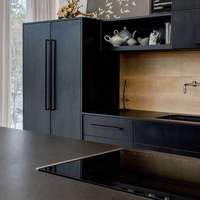 Meubles de cuisine modernes bicolores avec îlot en bois clair, portes plates noires et rangement intégré pour appareils électroménagers