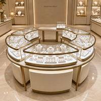 Ensemble de vitrines à bijoux sur mesure, disposition circulaire, verre incurvé, base blanche crème, garniture en métal doré pour les bijouteries haut de gamme