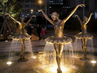 Sculpture de fontaine en bronze représentant une danseuse de ballet avec des thèmes d'anges et de musique dans un contexte de jardin