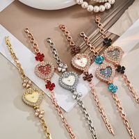 Montre pour femme élégante et chic de style luxe léger, avec chaîne à motif trèfle à quatre feuilles et quartz en forme de cœur