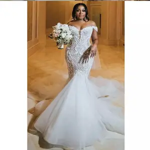 花嫁が身に着けているフィッシュテール付きアフリカの豪華なウェディングドレスマーメイドトランペットウェディングドレスセクシーなブライダルドレス