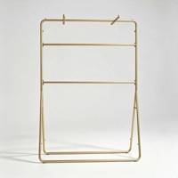 Porte-vêtements double suspendu en métal doré moderne avec pieds antidérapants et crochets supérieurs pour magasin de détail haut de gamme