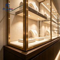 Vitrine de présentation de bijoux de luxe en bois foncé avec finition dorée, éclairée par LED, en verre trempé, pour boutique de bijoux et vente au détail