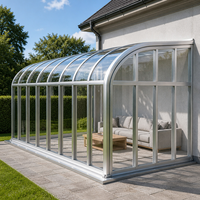 Véranda rétractable avec structure en aluminium, toit incurvé, verre transparent, paroi coulissante télescopique, fixée pour terrasse, patio, ou balcon.