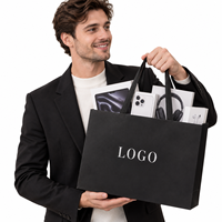 Sac cadeau en papier noir avec logo personnalisé et poignées en ruban pour l'emballage de produits électroniques 3C