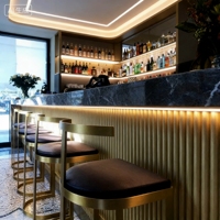 Comptoir de bar haut de gamme avec panneau rayé doré, dessus en marbre éclairé par LED, station de bar pour les établissements hôteliers de luxe