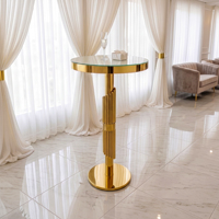 Table d'appoint ronde haute moderne à rainures verticales, avec plateau en verre et pied unique en acier inoxydable, idéale pour les mariages et salons.