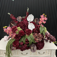 Composition florale en soie rouge bordeaux personnalisée, arche florale incurvée irrégulière avec des lianes vertes suspendues pour toile de fond de mariage d'automne