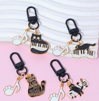 Porte-clés en alliage de zinc avec motif de petit chat noir musical de dessin animé et notes de piano, accessoire de sac mignon et original pour hommes et femmes