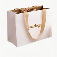 Sacs en papier carton ivoire personnalisés de luxe avec estampage à chaud doré et poignée en ruban pour boutiques de vêtements, bijoux et cadeaux