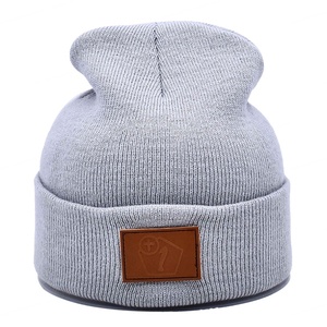 Bonnets en tricot de laine côtelé avec logo en cuir personnalisé unisexe en gros Bonnet d'hiver à revers chaud et de luxe pour femmes et hommes - Product Image 1
