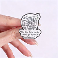 Broche en émail « Que laisse-t-on partir ? » avec grenouille espagnole motivante soufflant une pissenlit et un motif spirale dans un trou d'arbre, bijoux et badges