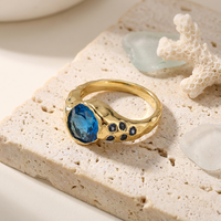 ZG Breiter Ring mit Hammerschlag-Optik, ovaler blauer Zirkonia im Lünettenfassung, Messing, vergoldet, Akzentstein-Schmuck