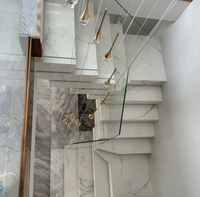 Escalier en marbre empilé lumineux avec garde-corps en verre et éclairage d'escalier chaleureux