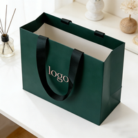 Sac d'emballage cadeau boutique en papier kraft noir recyclé écologique avec logo personnalisé et poignée pour la promotion de vêtements