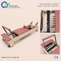 Reformer de Pilates en bois d'érable rose poussiéreux avec rail fixe, barre de repose-pieds intégrée et support à ressorts réglable pour les cours de bien-être