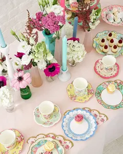 Бумажные тарелки, салфетки, чайные чашки и блюдца для чаепития в саду