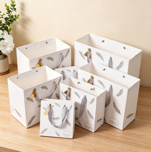 Sac en papier cadeau portable tendance, sac fourre-tout en papier blanc imprimé plumes argentées en gros pour l'emballage de cosmétiques et de bijoux de vacances - Product Image 2