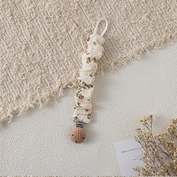 Attache-sucette artisanale en coton mousseline style bohème, motif floral vintage, avec chaîne en bois de hêtre à volants pour bébé
