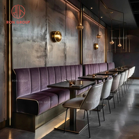 Ensemble de mobilier commercial moderne pour restaurant : banquette en velours violet avec chaise en cuir, tables carrées en bois foncé pour salle à manger d'hôtel