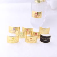 Autocollant de logo de marque classique OEM en métal doré, résistant à l'huile et à l'eau, pour emballage de parfum, personnalisable pour bouteilles