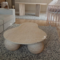 Table basse Kumusi en travertin avec plateau en forme de poire et pied sphérique