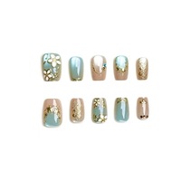 Ongles bleu brumeux à motif géométrique animalier, style français court, fleurs dorées, texture luxueuse haut de gamme