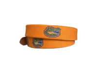 Cette ceinture en cuir brodée de style preppy présente une base orange et est ornée de la broderie emblématique du crocodile.