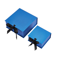 Boîte cadeau de luxe personnalisée en matériaux recyclés bleus brillants avec revêtement UV, doublure en éponge, fermeture magnétique et nœud en ruban