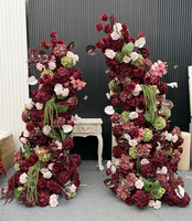 Composition florale en soie rouge bordeaux personnalisée, arche florale incurvée irrégulière avec des lianes vertes suspendues pour toile de fond de mariage d'automne