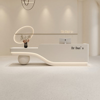 Bureau de réception moderne personnalisé à ondulations douces avec base sphérique unique pour clinique cosmétique, salon de manucure, spa de beauté