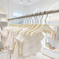 Vente en gros directe usine Cintre pour enfants en plastique beige avec crochet pivotant en métal, crochets à double sangle et pinces à jupe personnalisable