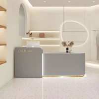 Comptoir de réception moderne en bois MDF avec éclairage LED, finition or, blanc et rose, forme oblongue, mobilier commercial pour hôtel, bar, centre commercial