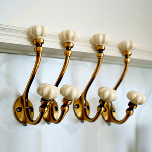 Ganchos Clásicos para Colgar en la Pared con Perillas de Cerámica, Acabado Dorado, Diseño Metálico Resistente para Almacenamiento de Ropa - Product Image 1