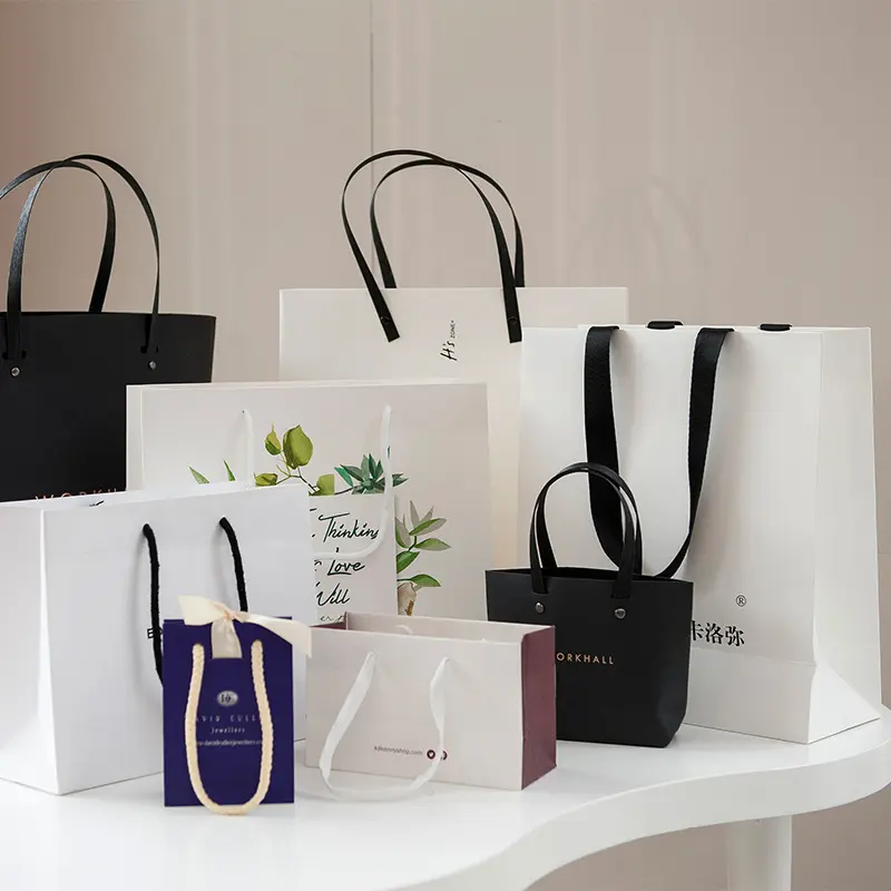 Sacs de transport blancs imprimés personnalisés Boutique de luxe vêtements au détail Shopping Sacs d'emballage en papier pour vêtements avec votre propre logo