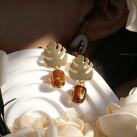 Boucles d'oreilles créoles motif feuille tropicale, en laiton artisanal, design ajouré, avec feuilles de bambou évoquant une coquille de tortue et pierres turquoise. Oreille
