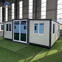 Entrepôt modulaire préfabriqué personnalisé avec porte coulissante pliante à double aile en verre, cadre en acier respirant, compatible cheminée et pieds réglables