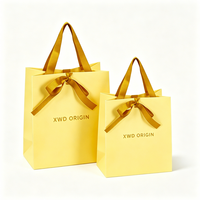 Terima pesanan OEM ODM, tas kertas kado dengan permukaan glossy, struktur pita terintegrasi, cetak custom dalam jumlah kecil.