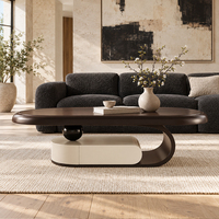 Table basse sculpturale contemporaine avec piétement en arc élancé, finition bicolore pour salon moderne et espace détente