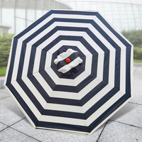 Parasol à mât central en aluminium imitation bois à long manche, base en marbre, design rayé pour terrasses extérieures et salons de thé.