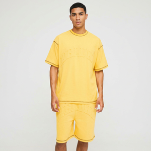 เสื้อยืดสีเหลืองโอเวอร์ไซส์ลายพิมพ์นูนเย็บตะเข็บตัดกัน และกางเกงขาสั้นผ้าฝ้ายทรงหลวมสำหรับผู้ชาย - Product Image 1